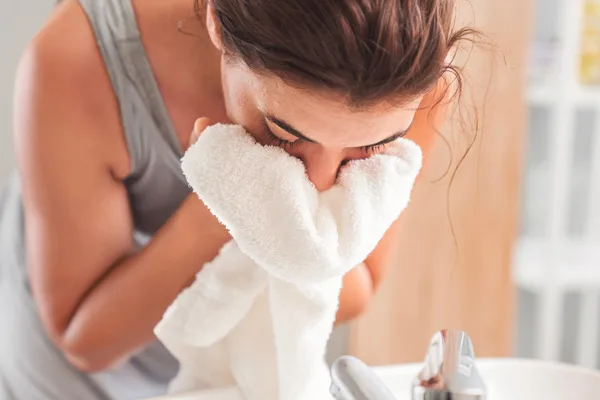 Kobieta oczyszcza skórę twarzy przy pomocy delikatnego, pieniącego się żelu myjącego